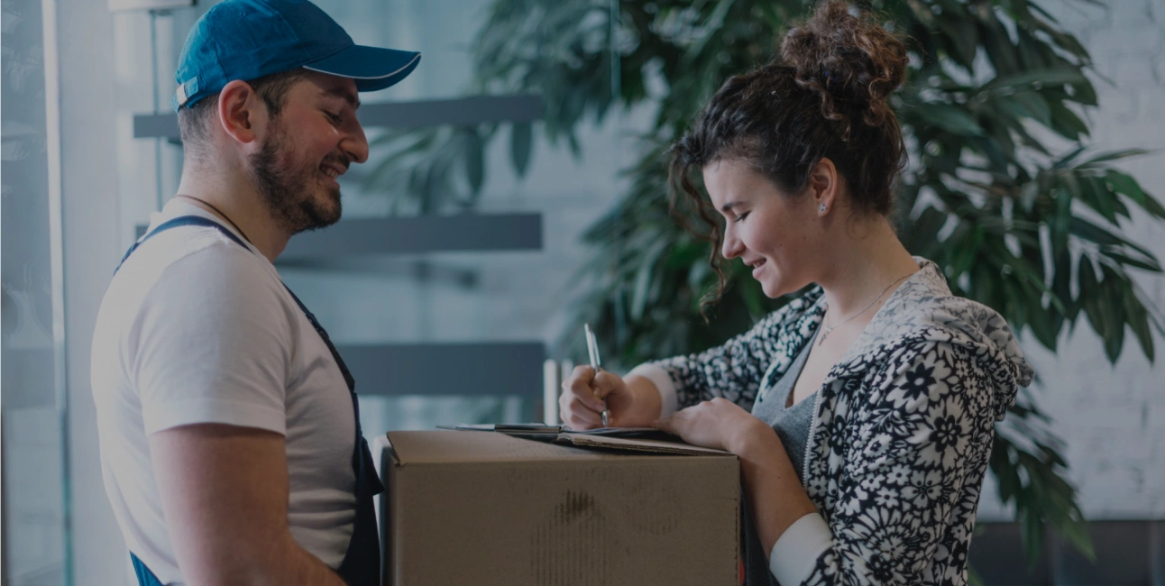 A woman signs for a package indoors